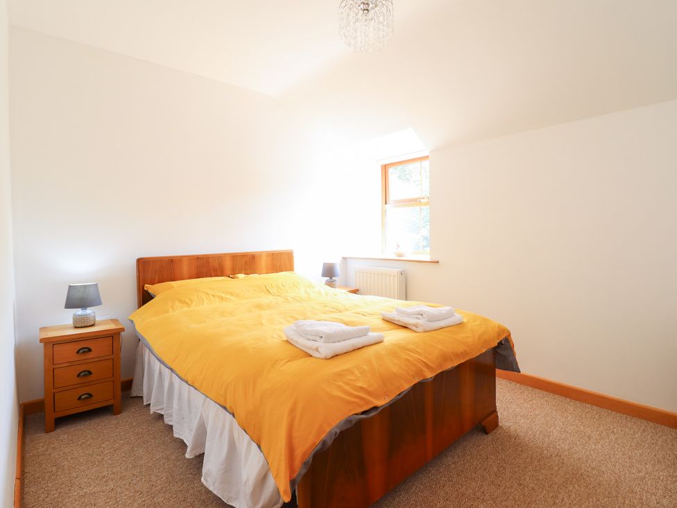 A bedroom with a bed and nightstand at Gwernffridd