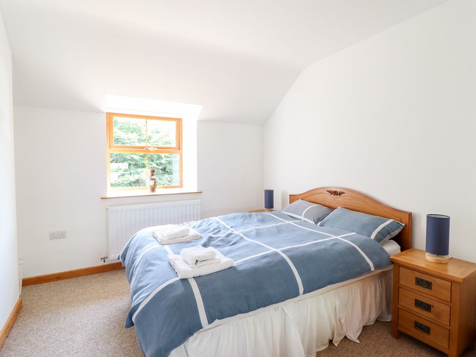 A bedroom with a bed and a window at Gwernffridd