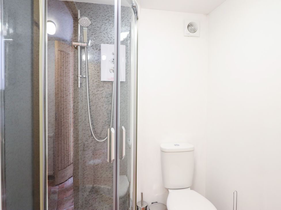 A bathroom with a shower and a toilet at Gwernffridd