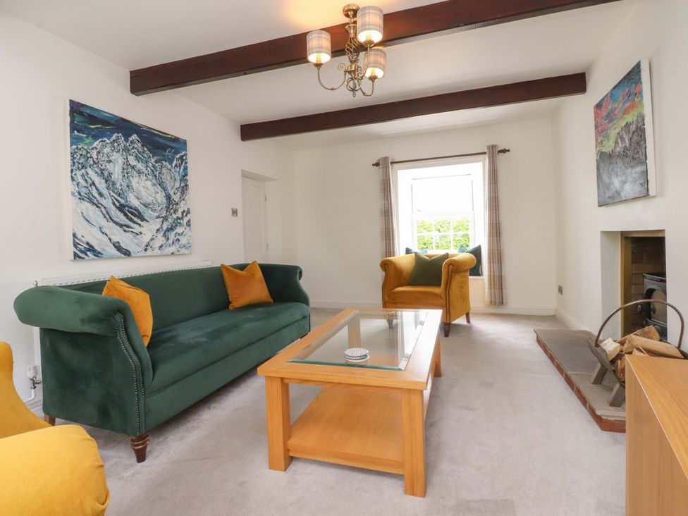 A living room with a green sofa and coffee table at Rose Tree Cottage in Skipton