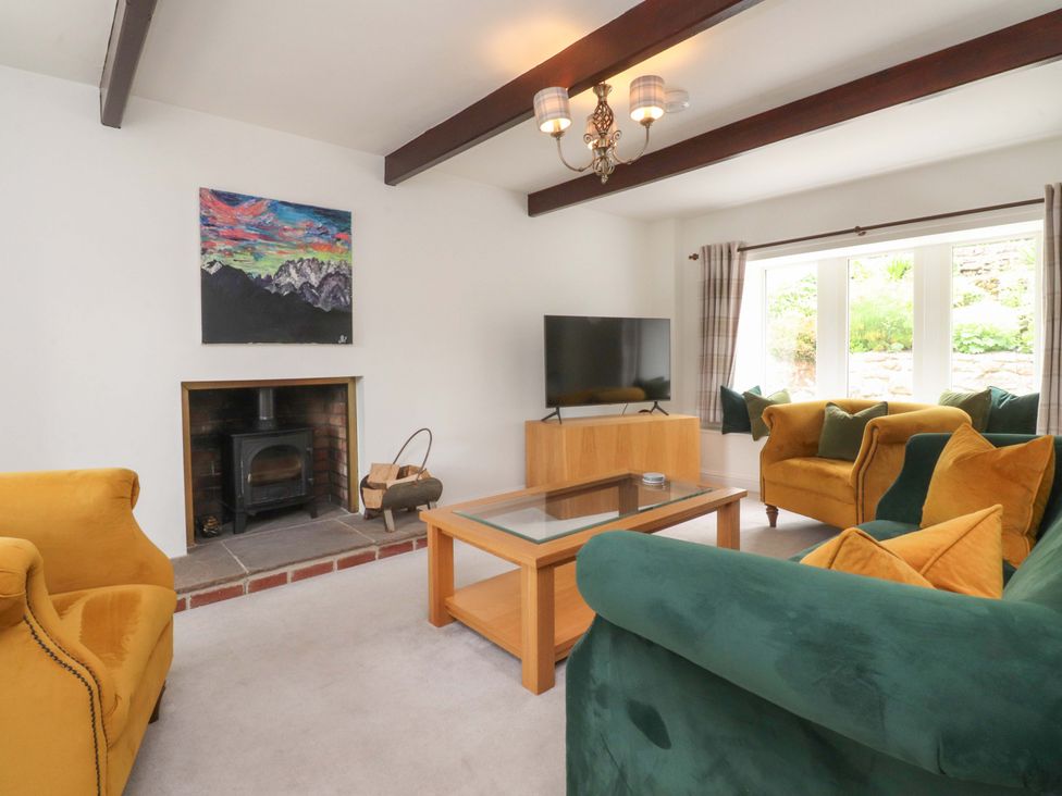 A living room with a television and a fireplace at Rose Tree Cottage in Skipton