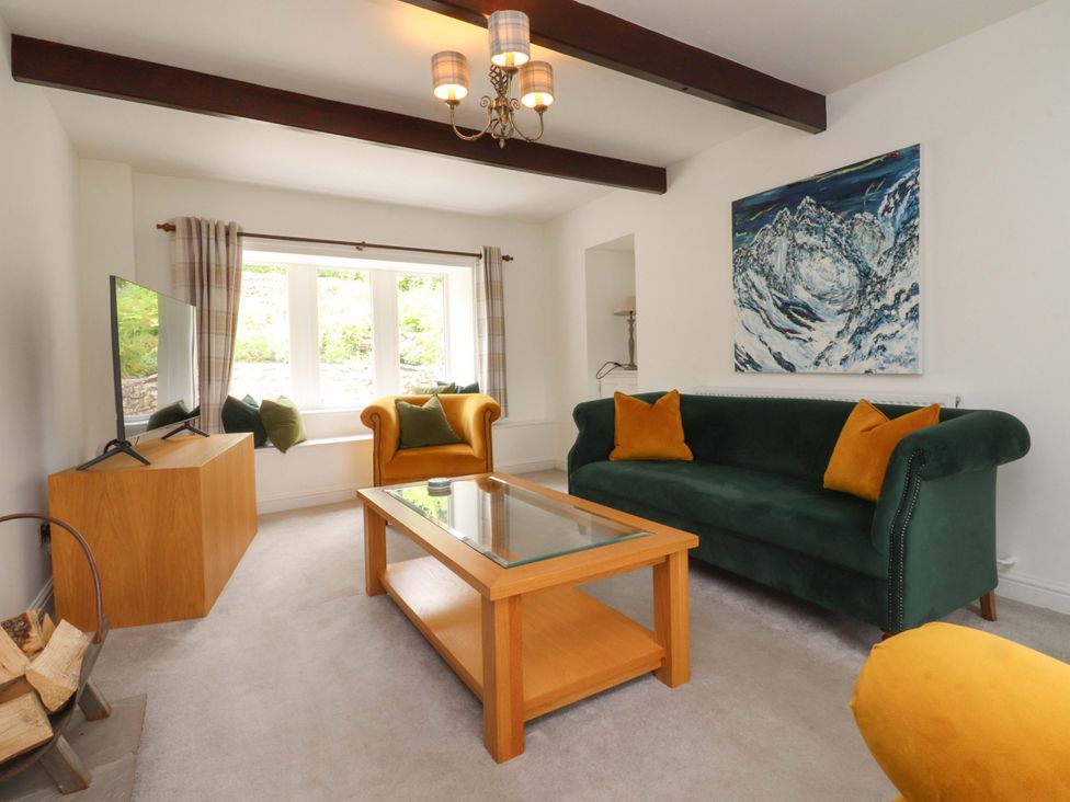 A living room with a television and sofa at Rose Tree Cottage in Skipton