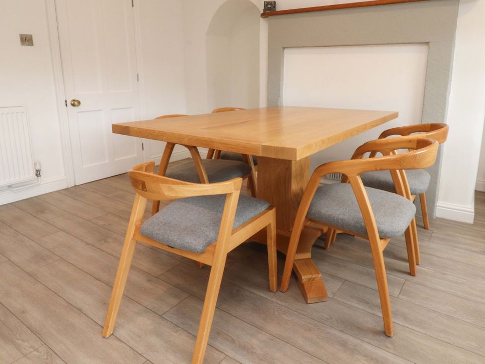 A dining room with a wooden table and chairs at Rose Tree Cottage in Skipton