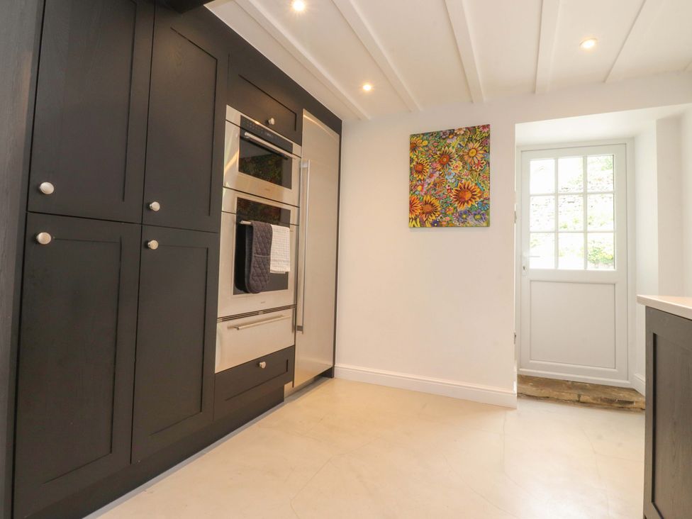 A kitchen with cabinets and appliances at Rose Tree Cottage in Skipton