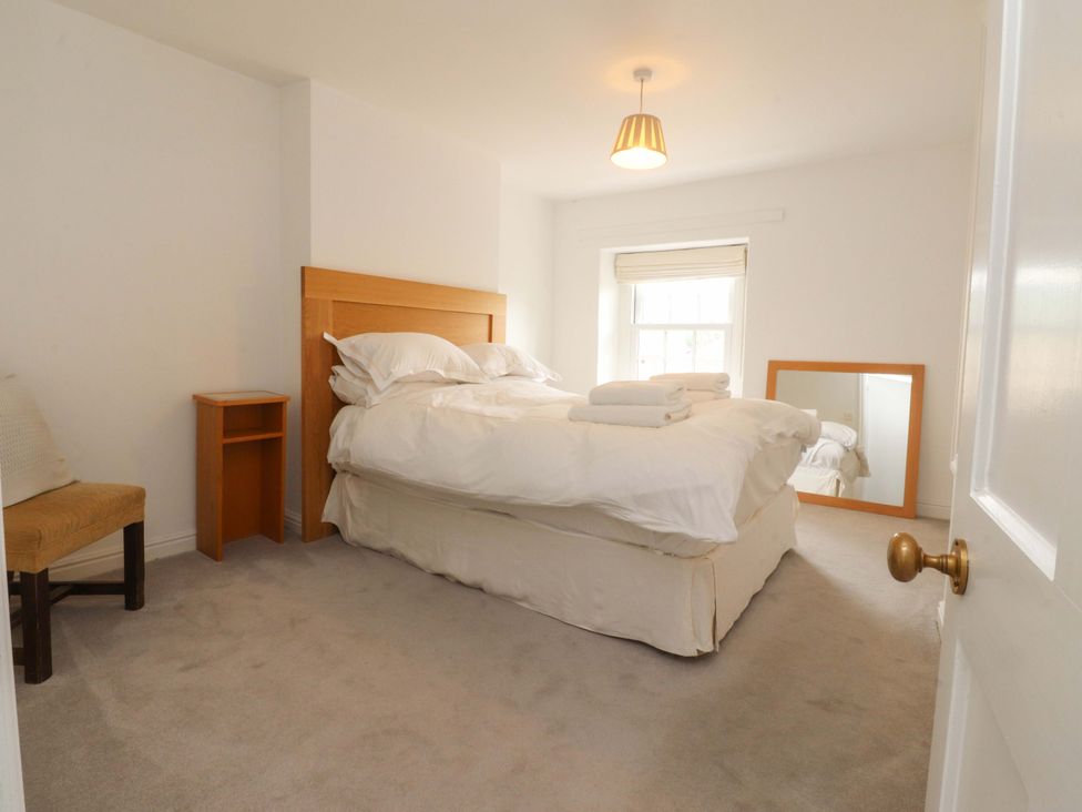 A bedroom with a bed and bedside table at Rose Tree Cottage in Skipton