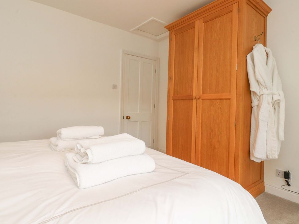 A bedroom with a bed and wardrobe at Rose Tree Cottage in Skipton