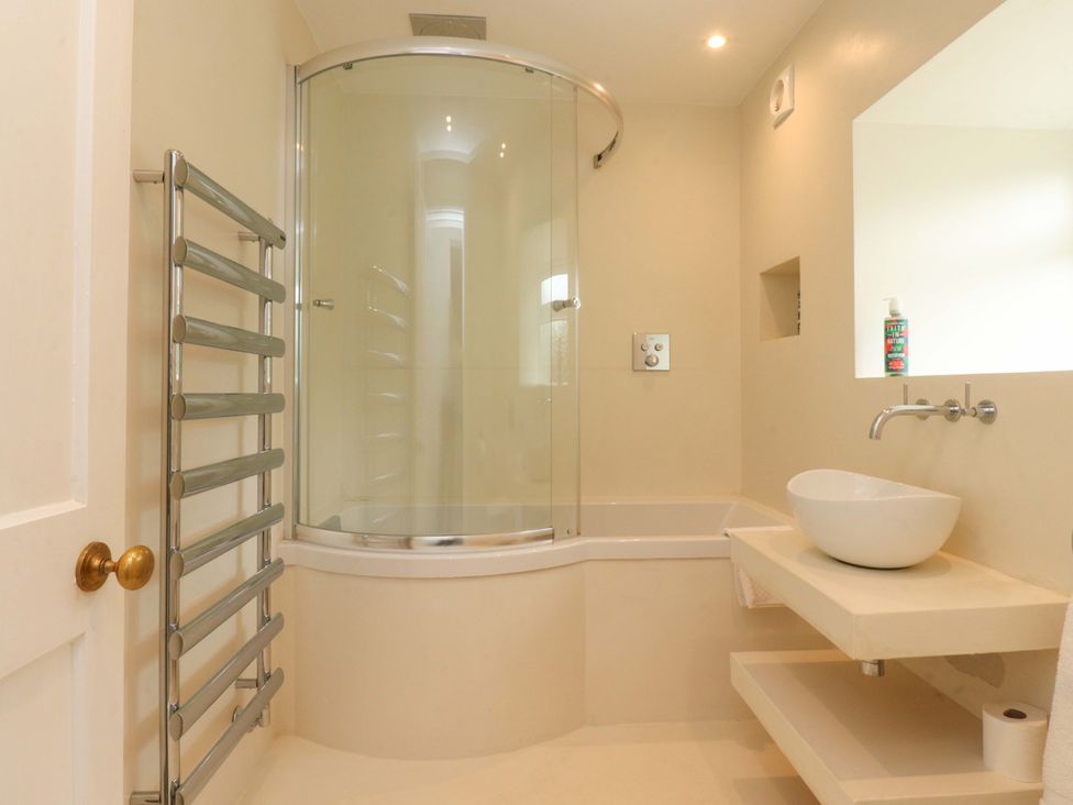 A bathroom featuring a shower, wash basin, and towel radiator at Rose Tree Cottage Skipton
