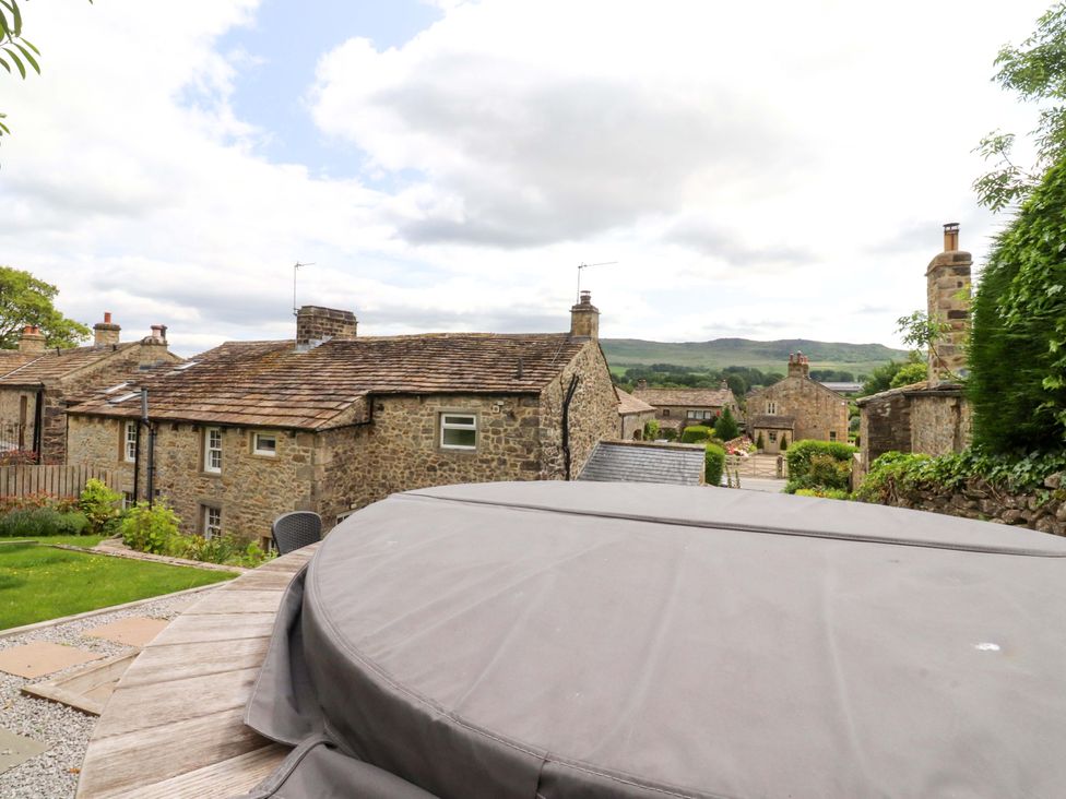 An outdoor view of houses and a hot tub at Rose Tree Cottage in Skipton