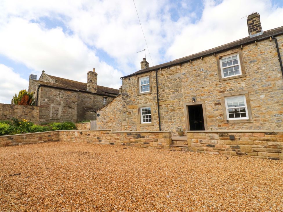 A house with stone walls and gravel garden at Rose Tree Cottage in Skipton