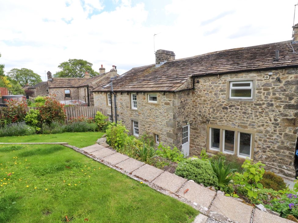 A garden with house and foliage at Rose Tree Cottage in Skipton