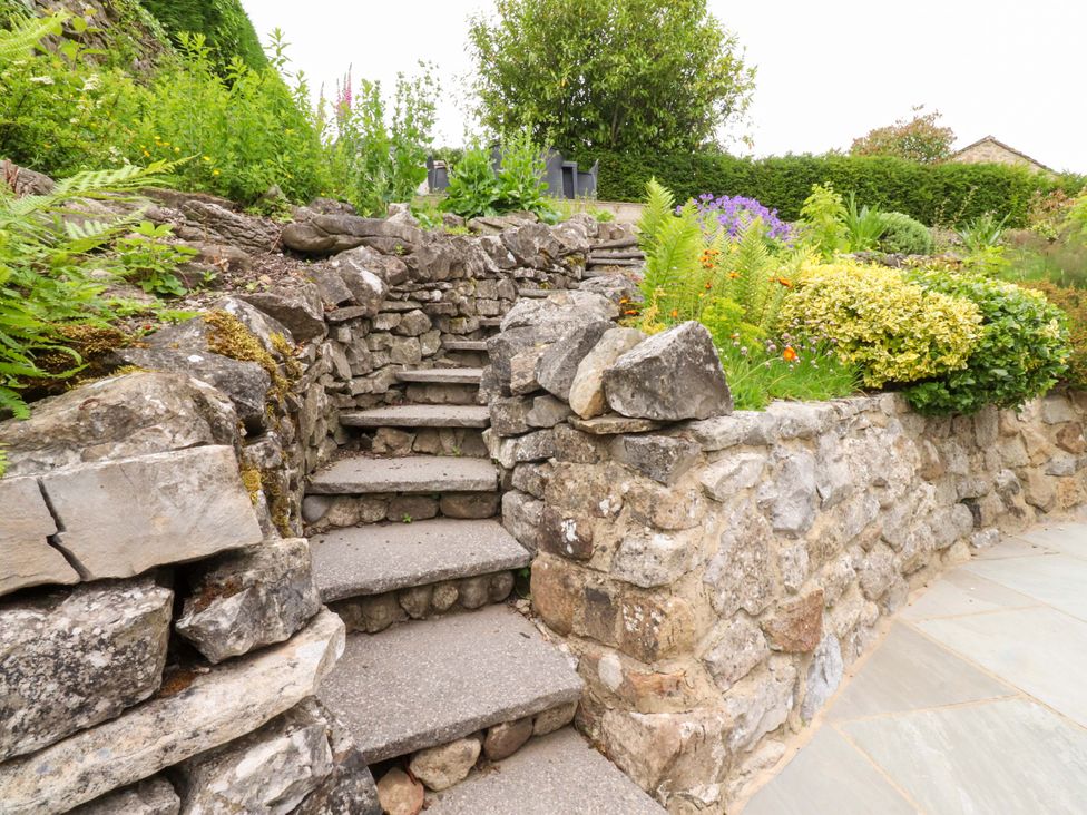 A garden with stone steps and plants at Rose Tree Cottage in Skipton