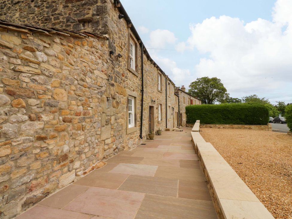 An outdoor area with stone walls and a pathway at Rose Tree Cottage in Skipton