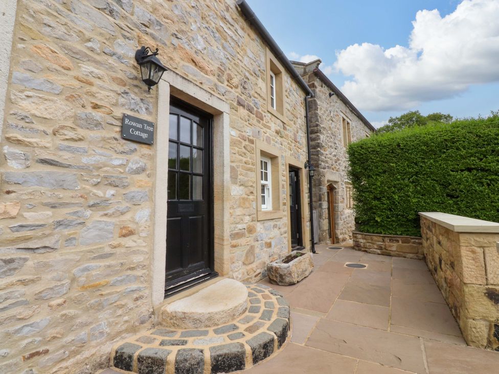 An entrance with stone wall and door at Rowan Tree Cottage in Skipsea