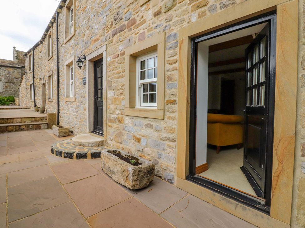 An outdoor area with stone wall and door at Rowan Tree Cottage Skipsea