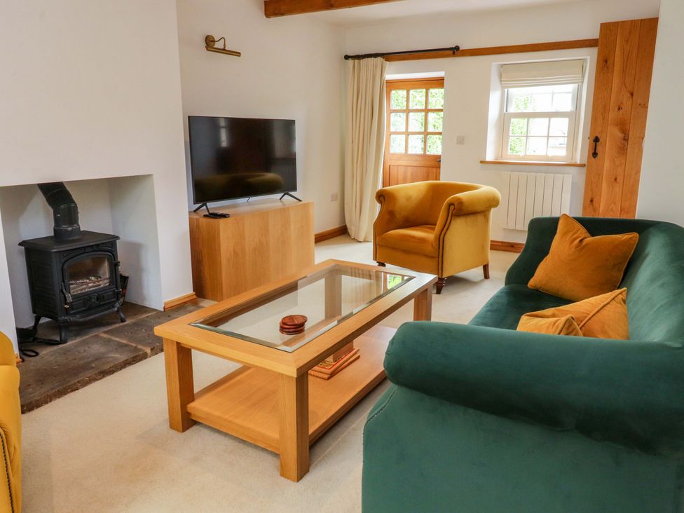 A living room with a tv and fireplace at Rowan Tree Cottage in Skipsea