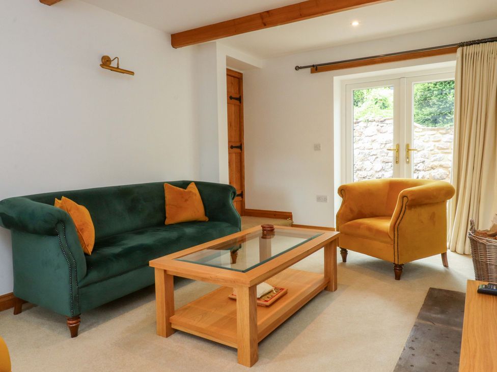 A living room with a sofa and coffee table at Rowan Tree Cottage in Skipsea
