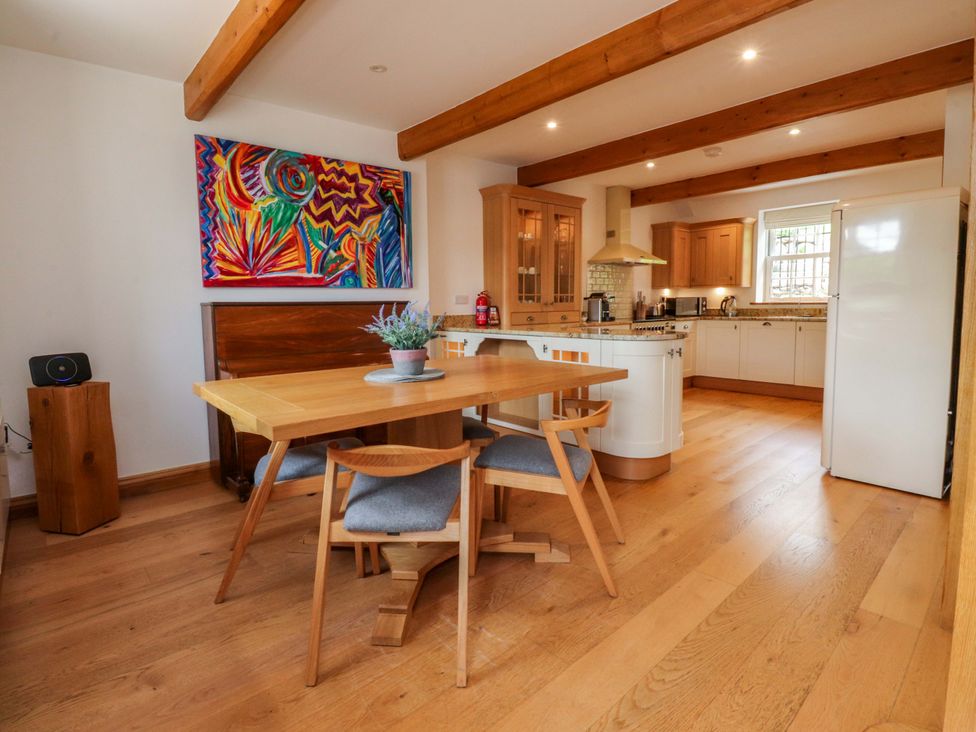 A dining room with a table and chairs at Rowan Tree Cottage Skipsea