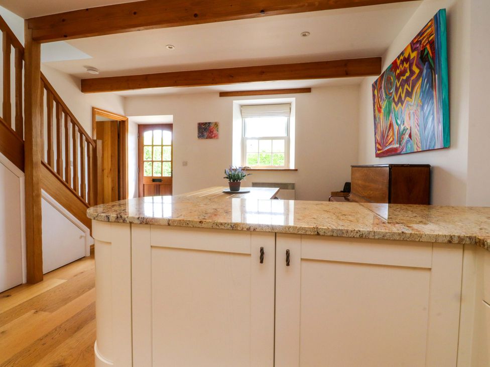 A kitchen with a countertop and staircase at Rowan Tree Cottage in Skipsea