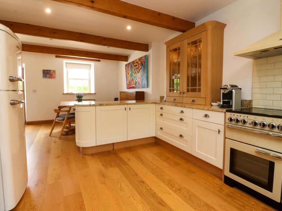 A kitchen with cabinets and appliances at Rowan Tree Cottage in Skipsea
