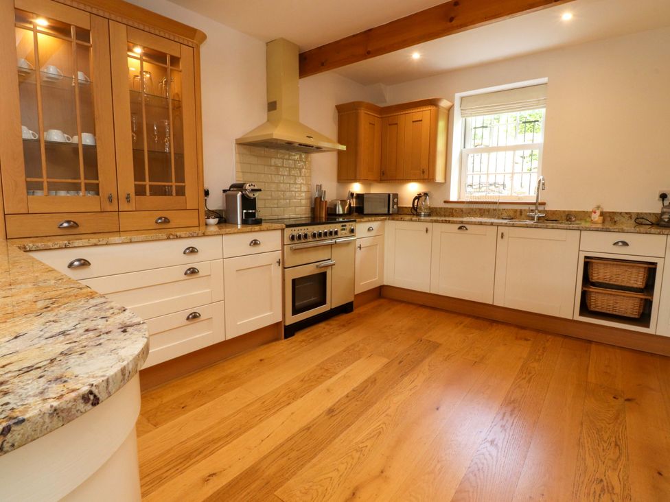 A kitchen with cabinets and appliances at Rowan Tree Cottage in Skipsea