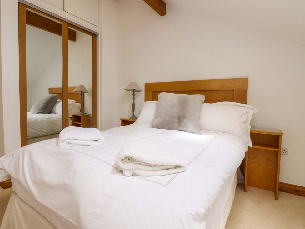 A bedroom with a bed and nightstand at Rowan Tree Cottage in Skipsea