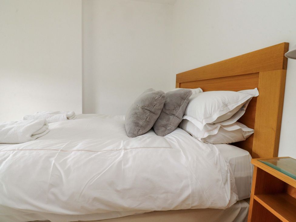 A bedroom with a bed and pillows at Rowan Tree Cottage in Skipsea