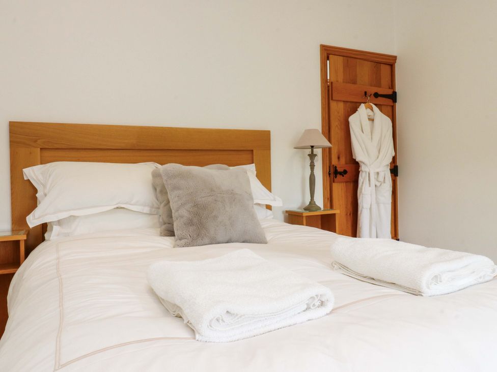 A bedroom with a bed and bedside table at Rowan Tree Cottage in Skipsea