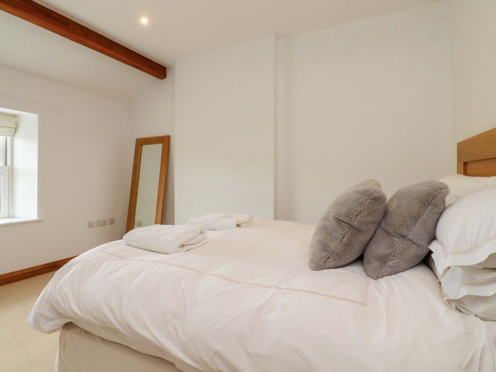 A bedroom with a bed and a mirror at Rowan Tree Cottage in Skipsea