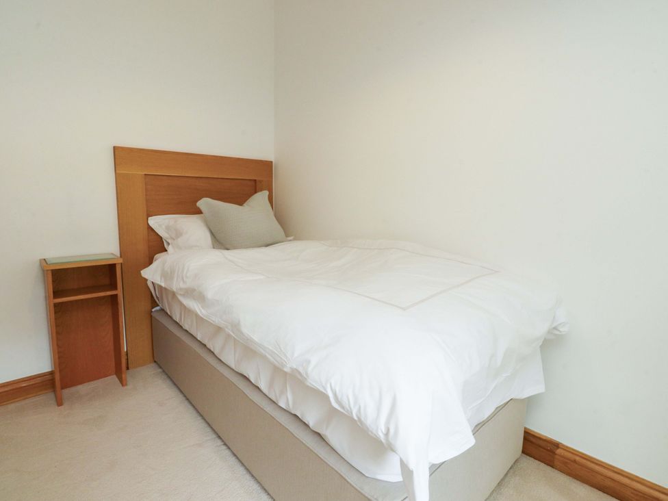 A bedroom with a bed and bedside table at Rowan Tree Cottage Skipsea