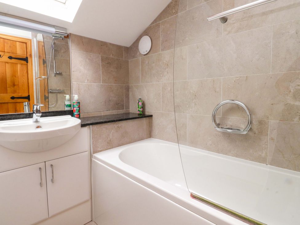 A bathroom with a sink and bathtub at Rowan Tree Cottage in Skipsea