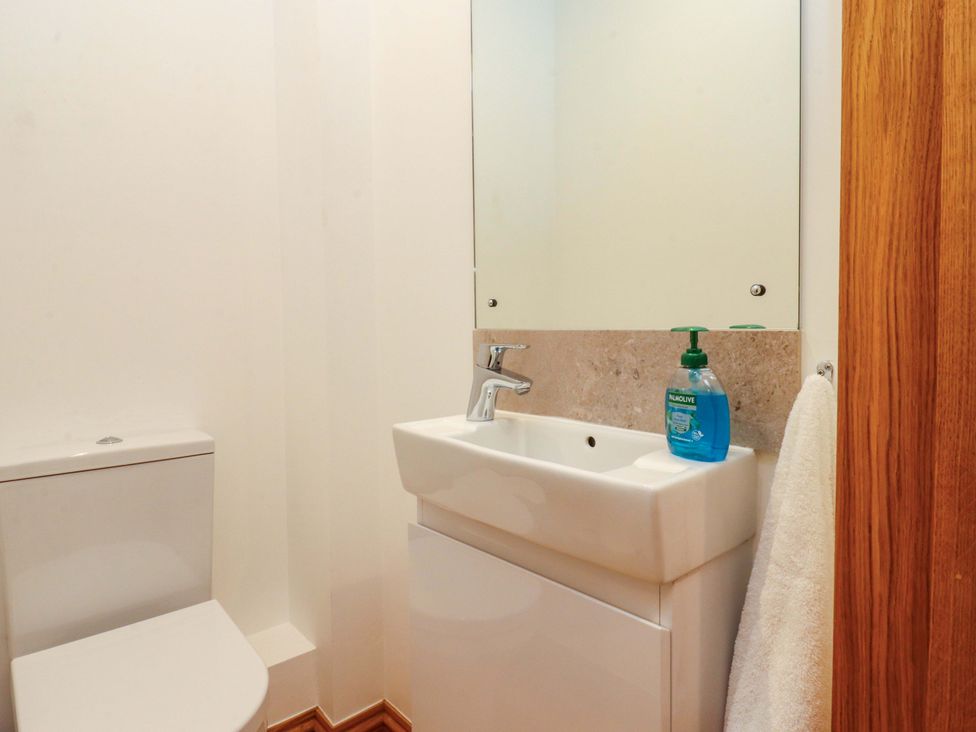 A bathroom with a toilet and sink at Rowan Tree Cottage Skipsea