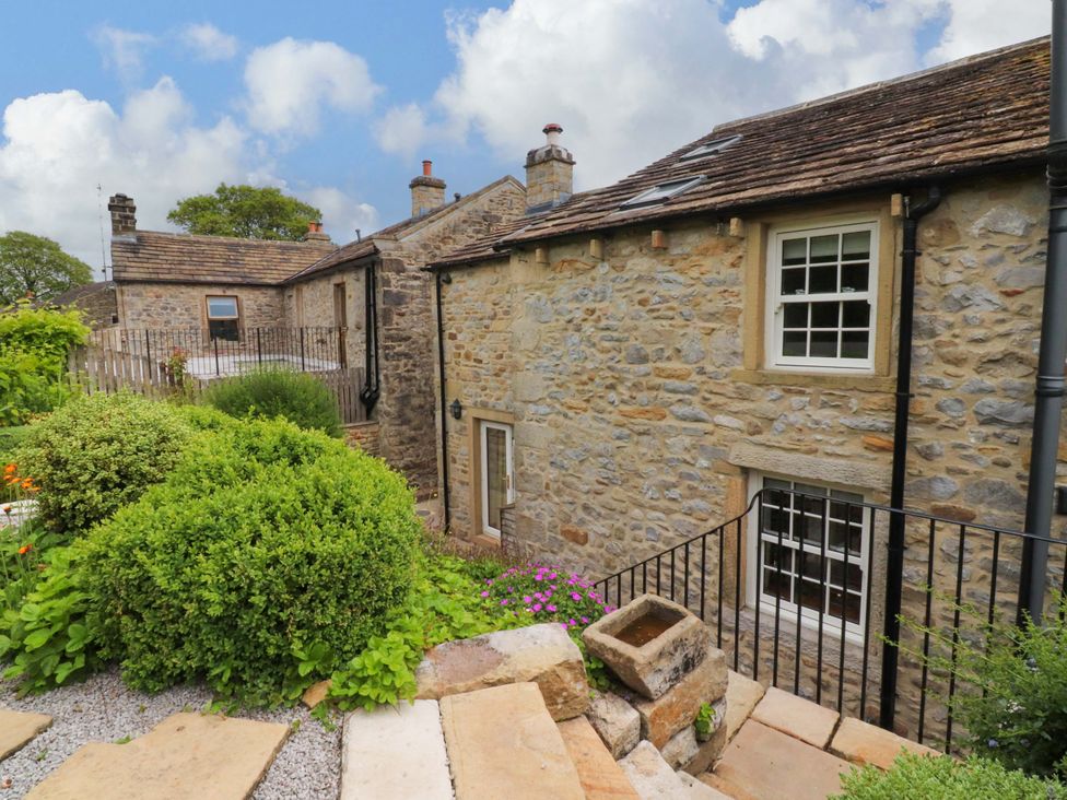 An outdoor area with stone walls and a pathway at Rowan Tree Cottage in Skipsea