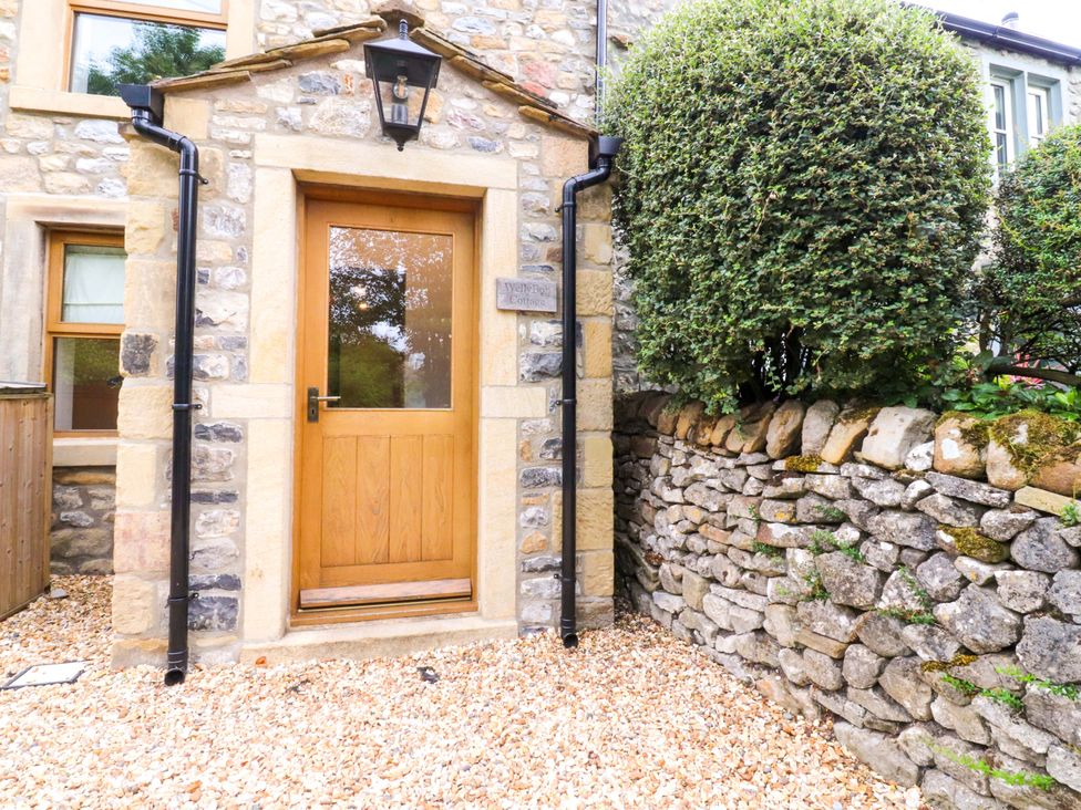 An entrance with a door and stone wall at Welly Bob Cottage in Airton