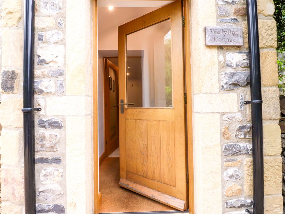 An entrance with an open door and a sign at Welly Bob Cottage Airton