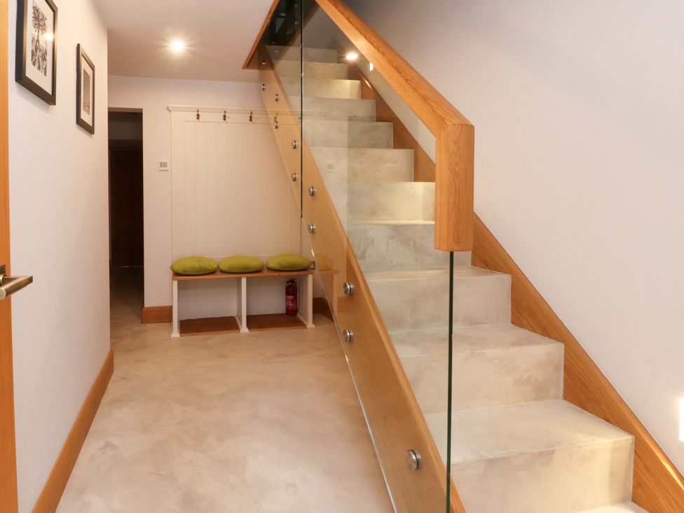 A hallway with a staircase and bench at Welly Bob Cottage Airton