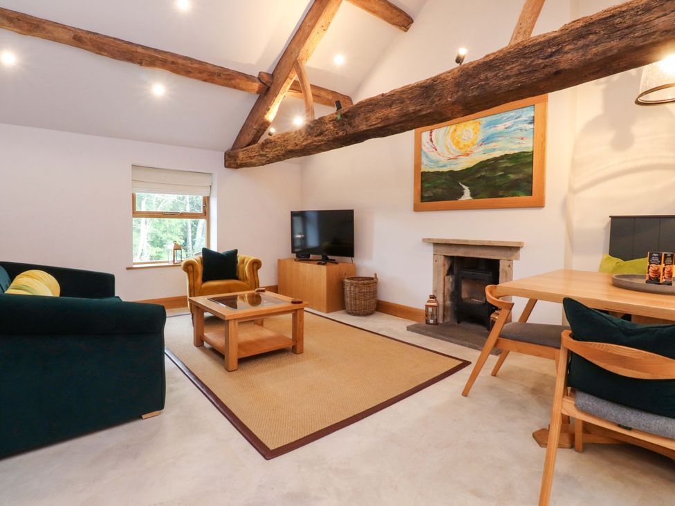 A living room with a sofa, coffee table, and TV at Welly Bob Cottage Airton