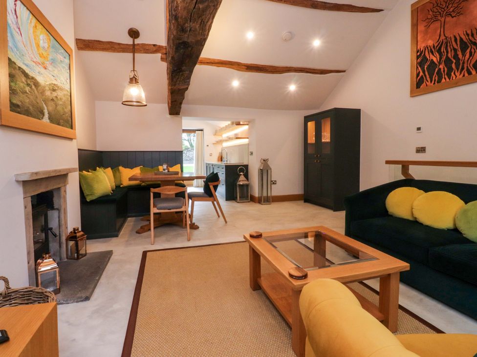 A living room with a sofa and dining area at Welly Bob Cottage in Airton