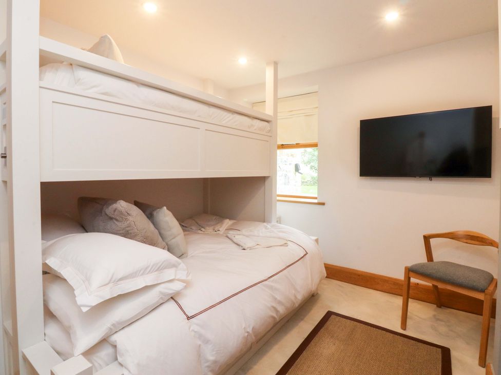 A bedroom with a bunk bed and a television at Welly Bob Cottage in Airton