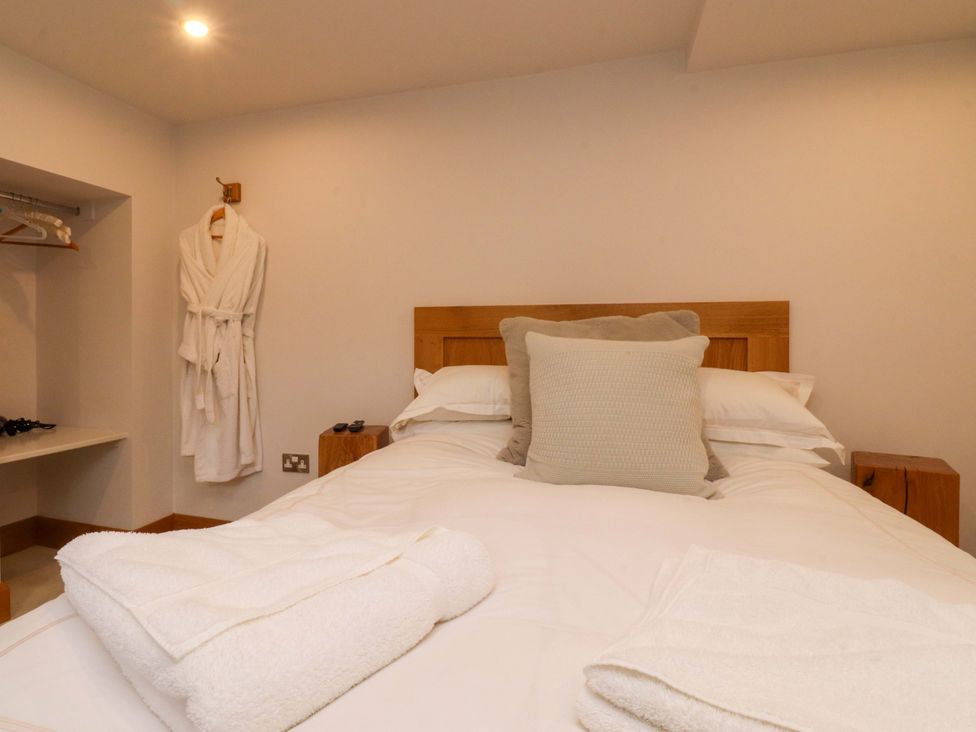 A bedroom with a bed and towels at Welly Bob Cottage Airton