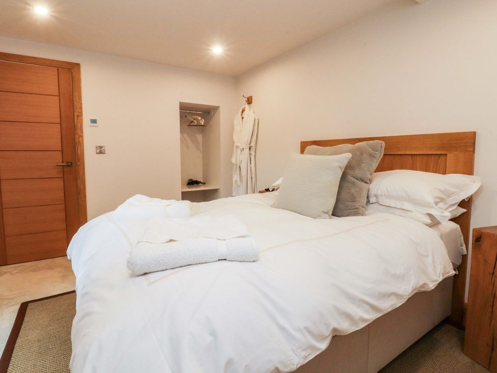 A bedroom with a bed and shelf at Welly Bob Cottage in Airton