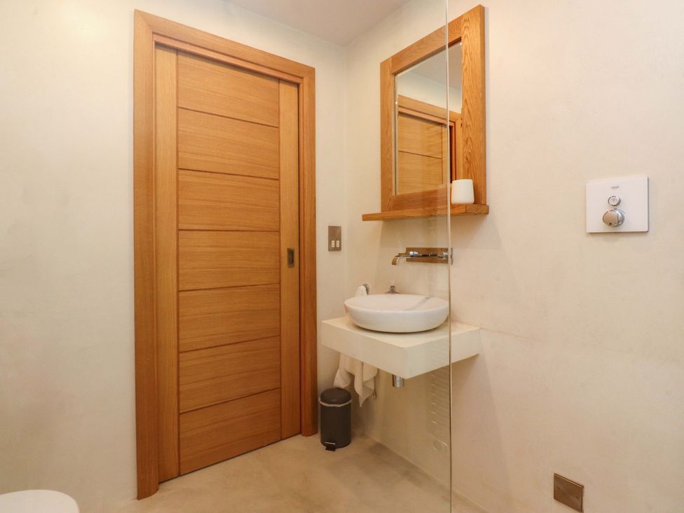 A bathroom with a sink and mirror at Welly Bob Cottage in Airton