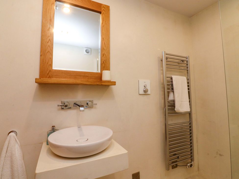 A bathroom with a sink and mirror at Welly Bob Cottage in Airton