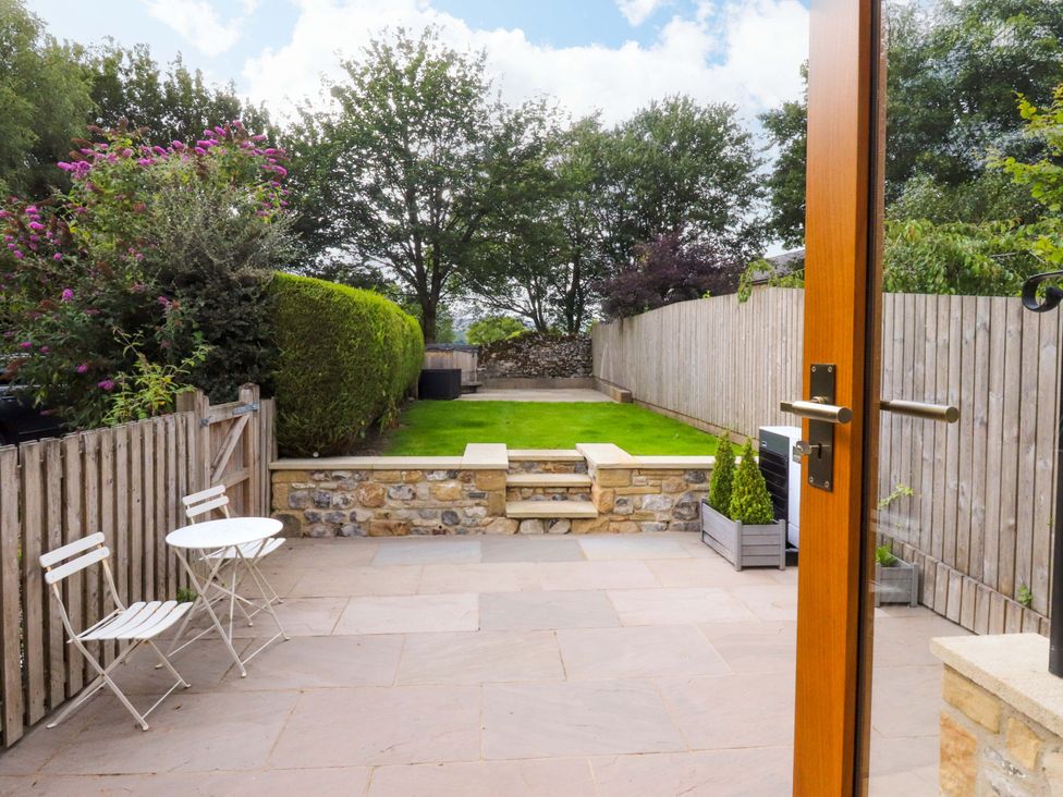 A garden with seating area and grass at Welly Bob Cottage Airton