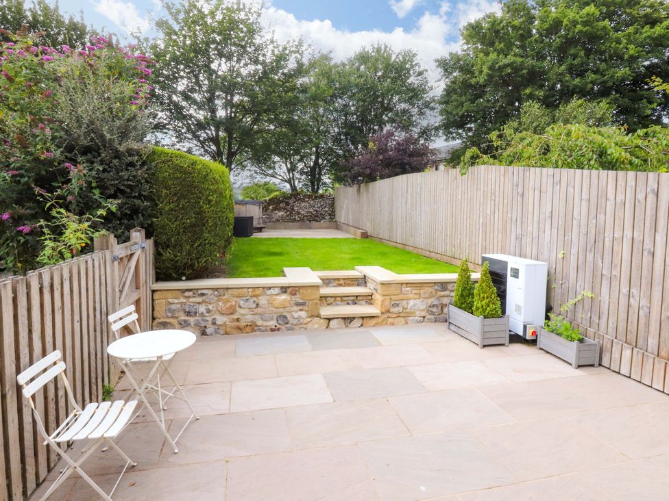 A garden with a table and chairs at Welly Bob Cottage in Airton