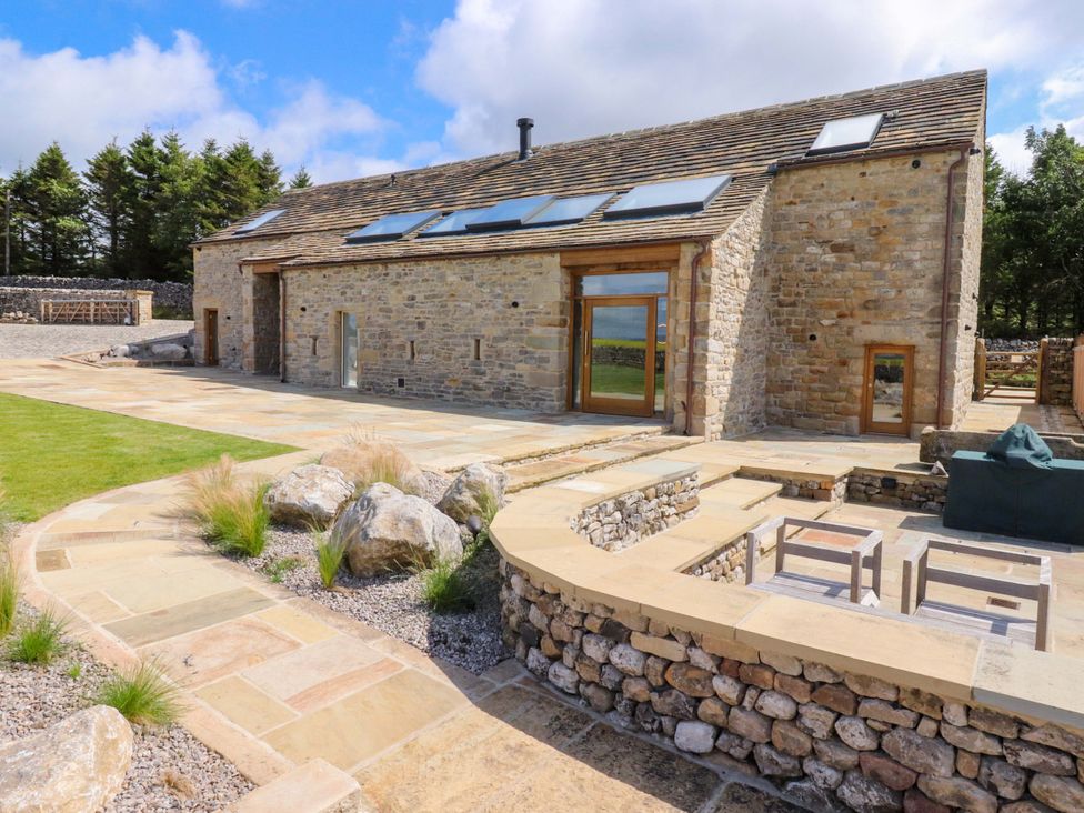 A barn with stone walls and a patio area at Carden Laithe Barn Threshfield