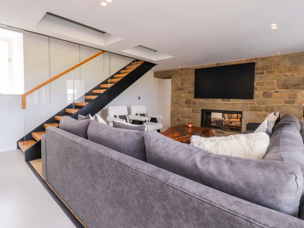 A living room with a sofa and staircase at Carden Laithe Barn Threshfield