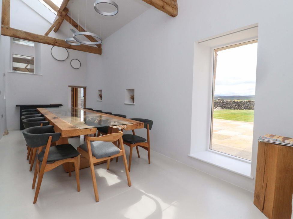 A dining room with a large table and chairs at Carden Laithe Barn in Threshfield