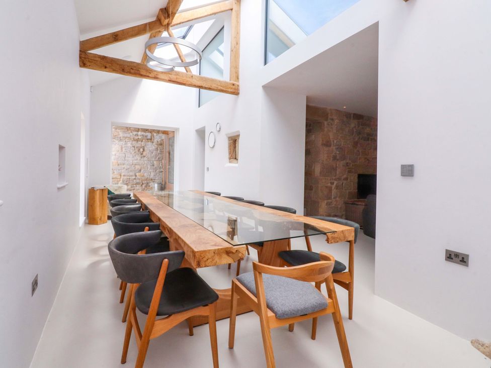 A dining room with a glass table and wooden chairs at Carden Laithe Barn Threshfield