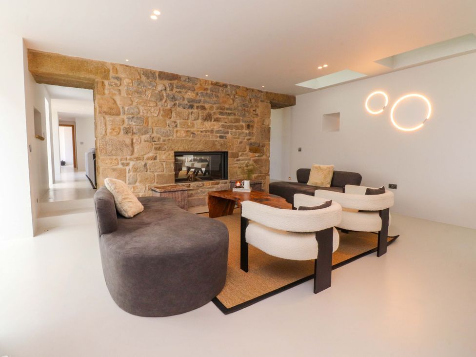 A living room with a fireplace and seating area at Carden Laithe Barn in Threshfield