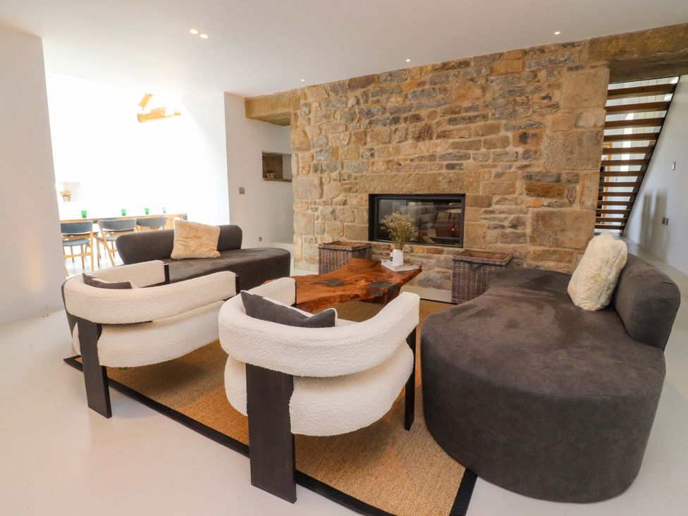 A living room with a sofa, chairs, and a fireplace at Carden Laithe Barn Threshfield